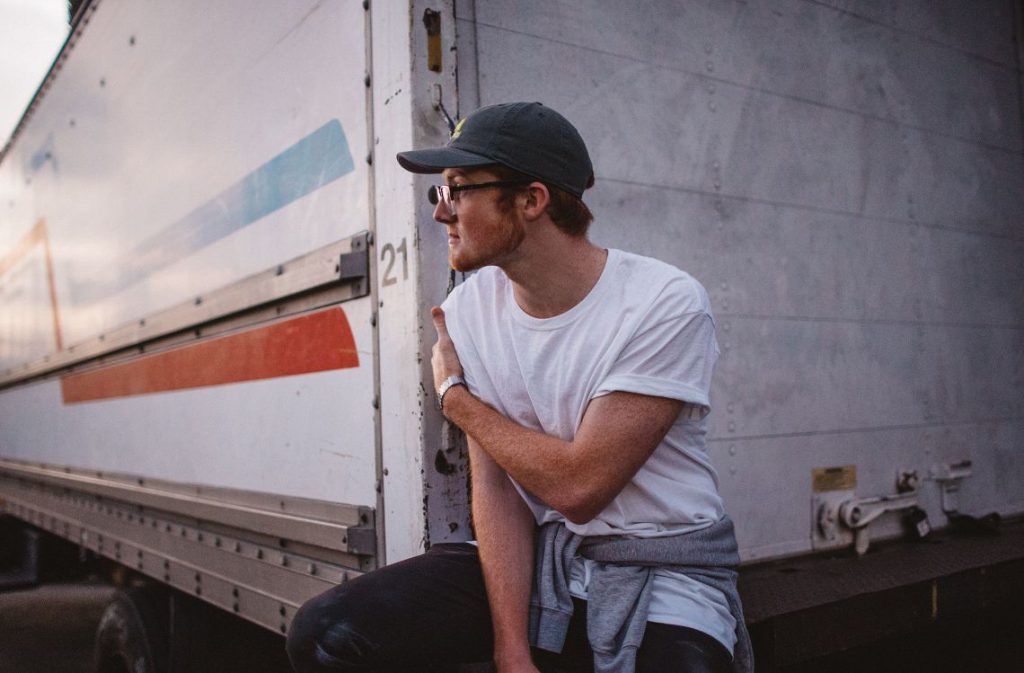 Jeune homme devant un camion utilitaire