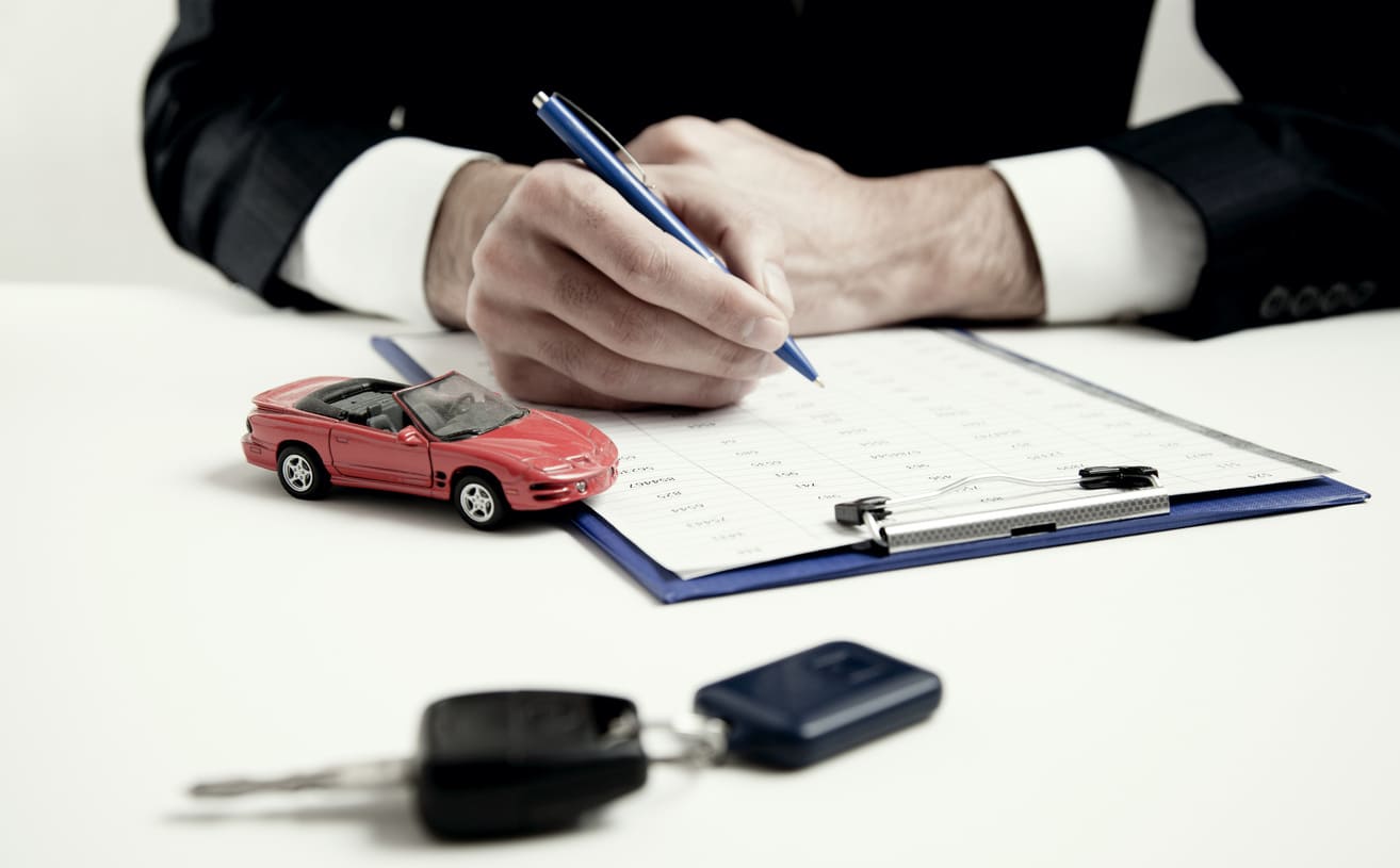 bloc note avec une petite voiture rouge et clé