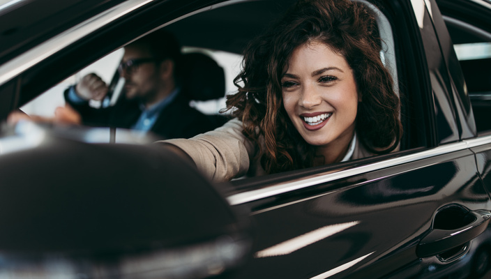 femme qui regarde son rétro en souriant